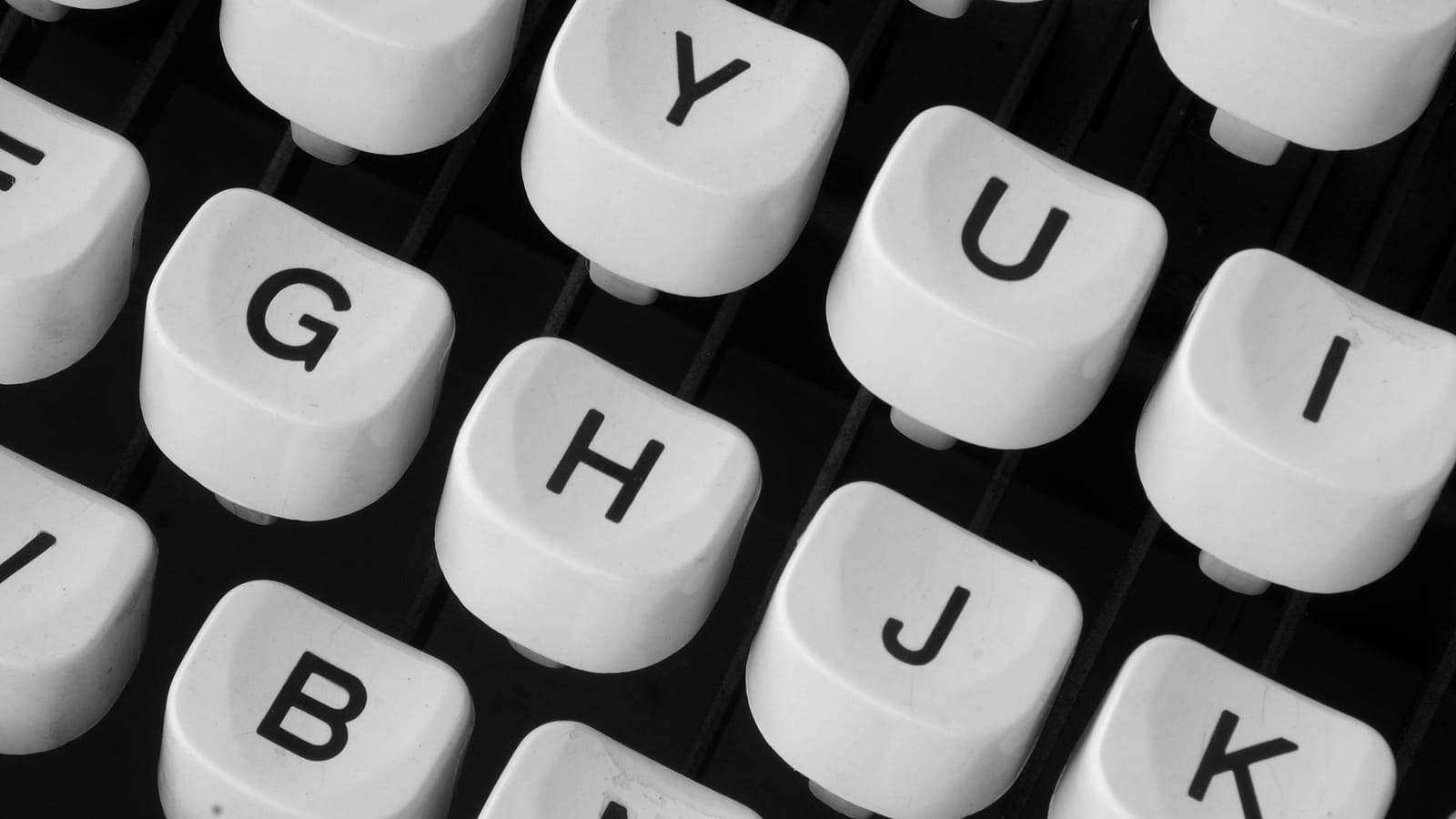 Close-up of white typewriter keys on a black keyboard.